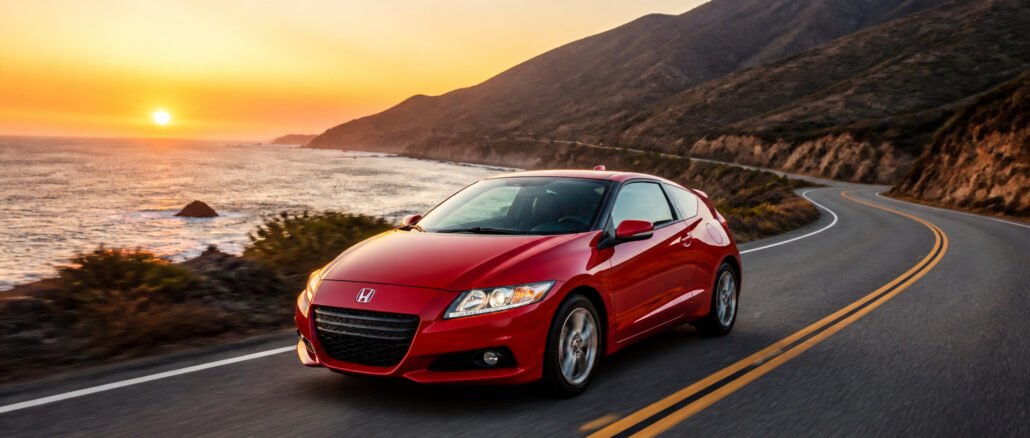 Honda cr z rouge sur route cotiere au coucher du soleil