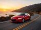 Honda cr z rouge sur route cotiere au coucher du soleil